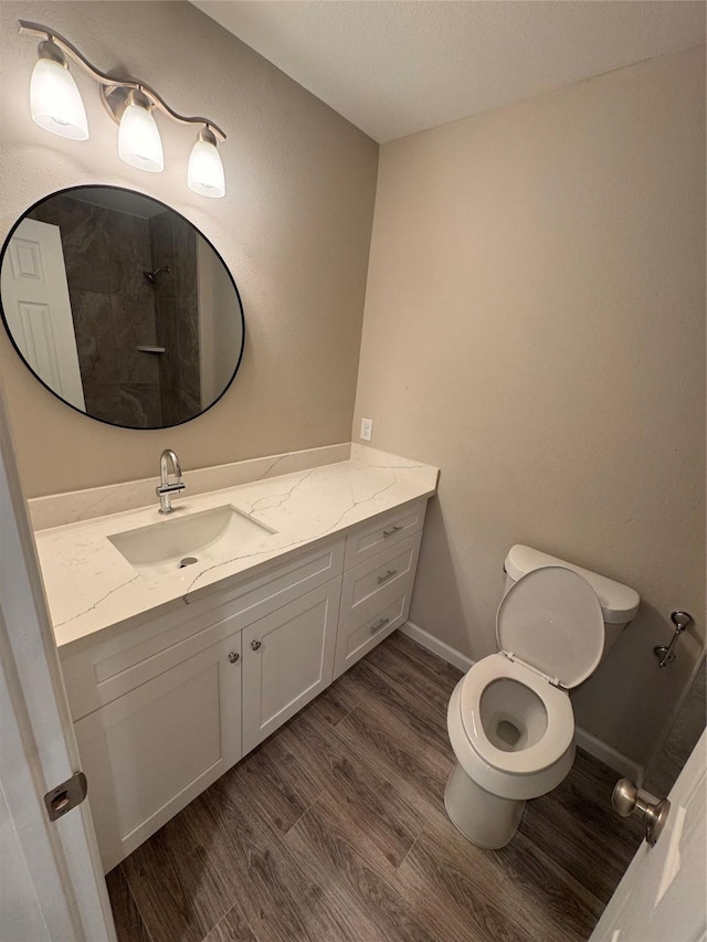 bathroom featuring vanity, wood-type flooring, and toilet