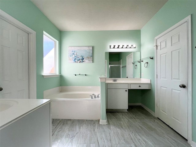 bathroom featuring vanity and independent shower and bath