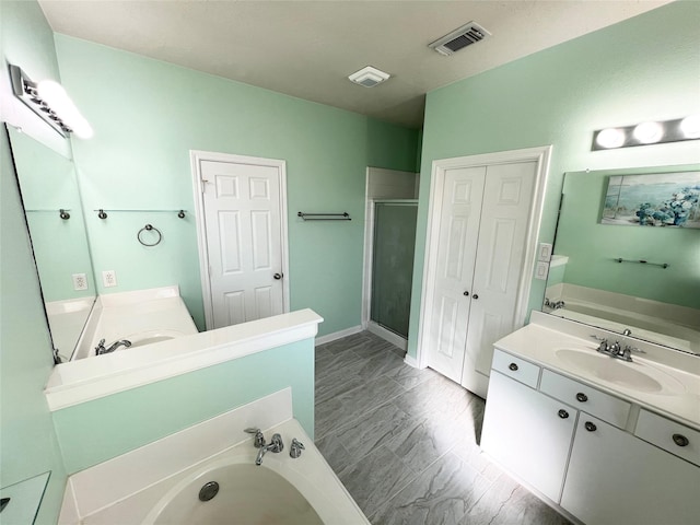 bathroom featuring separate shower and tub and vanity