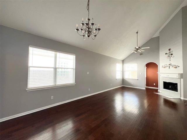 unfurnished living room with ceiling fan with notable chandelier, dark hardwood / wood-style flooring, and high vaulted ceiling