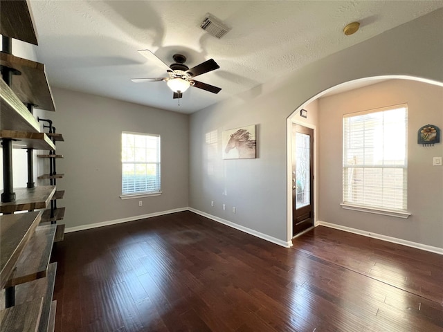 interior space with a textured ceiling, dark hardwood / wood-style flooring, and ceiling fan