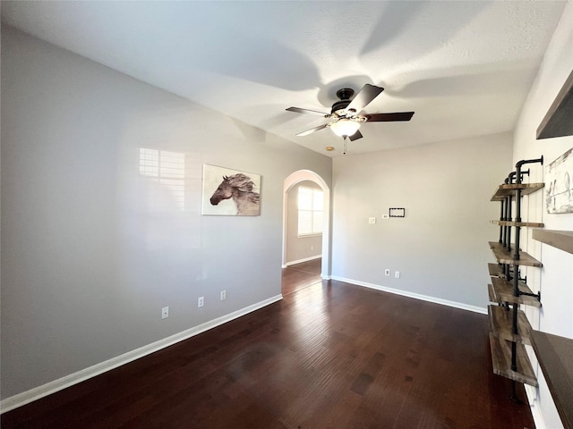 spare room with ceiling fan and dark wood-type flooring