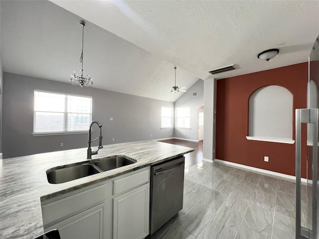 kitchen with stainless steel dishwasher, a textured ceiling, vaulted ceiling, sink, and white cabinets