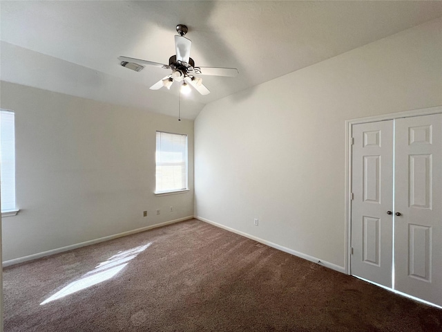 carpeted empty room featuring ceiling fan and lofted ceiling