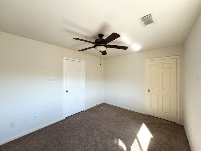 unfurnished room with ceiling fan and dark carpet