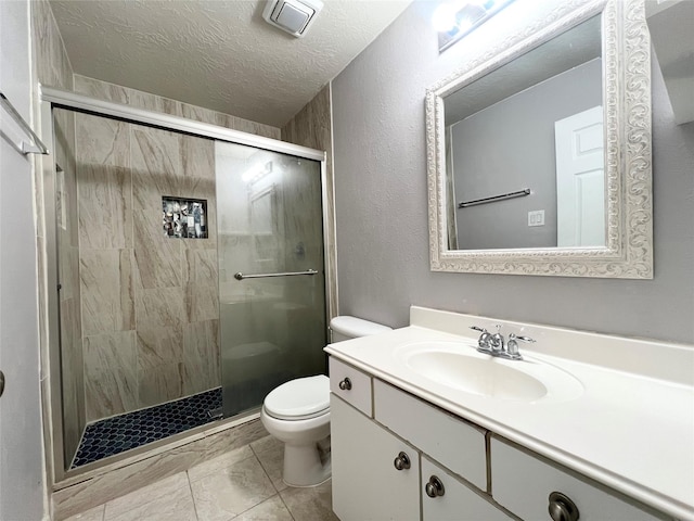 bathroom with vanity, tile patterned flooring, toilet, a textured ceiling, and walk in shower