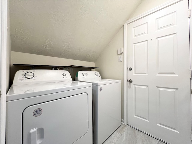 laundry room with washing machine and dryer and a textured ceiling