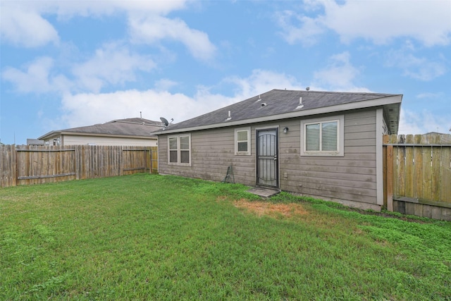 rear view of property with a yard