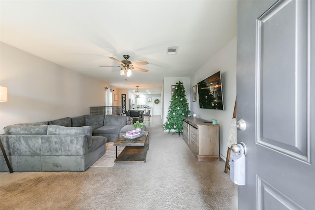 living room with ceiling fan and light colored carpet