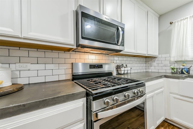 kitchen with white cabinets, appliances with stainless steel finishes, and decorative backsplash