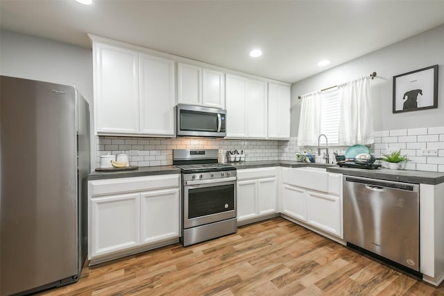 kitchen featuring white cabinets, stainless steel appliances, light hardwood / wood-style floors, and sink