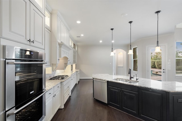 kitchen with stainless steel appliances, sink, a center island with sink, white cabinets, and dark hardwood / wood-style floors