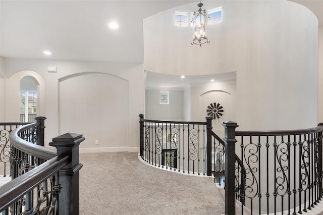 hall with carpet flooring and a chandelier