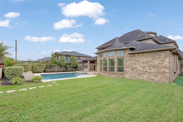 back of house with a lawn and a fenced in pool