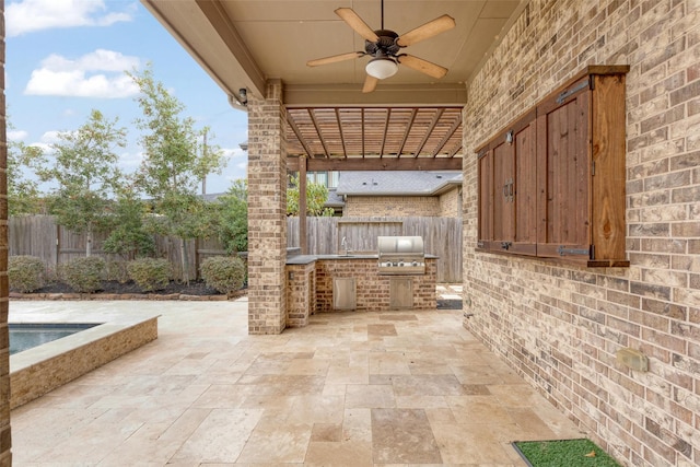 view of patio with area for grilling, ceiling fan, and an outdoor kitchen