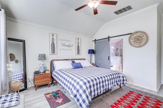 bedroom with ornamental molding, ceiling fan, a barn door, light hardwood / wood-style floors, and lofted ceiling