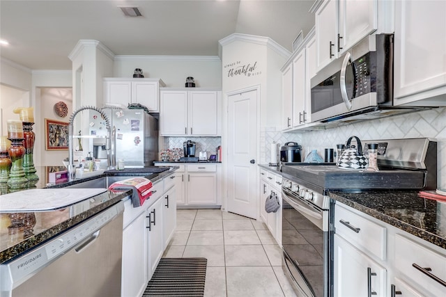 kitchen featuring tasteful backsplash, crown molding, white cabinets, and stainless steel appliances