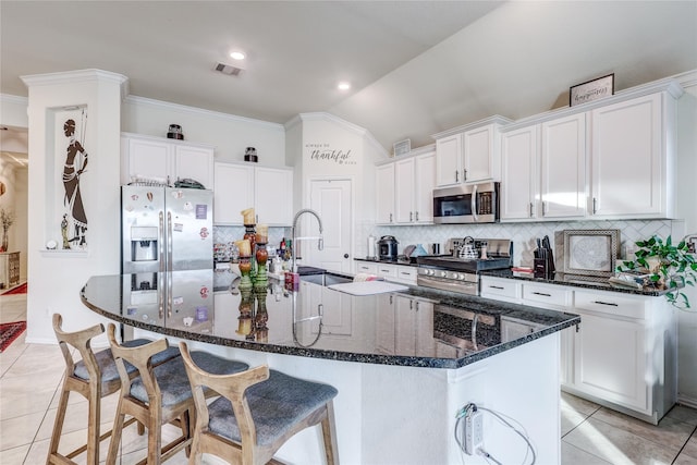 kitchen with sink, white cabinetry, stainless steel appliances, and vaulted ceiling