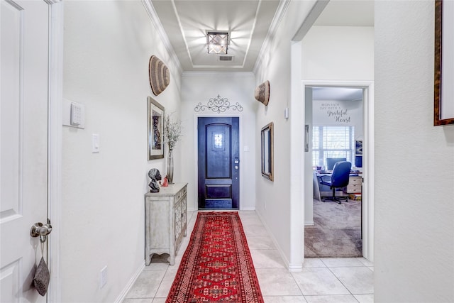 foyer with crown molding and light tile patterned floors