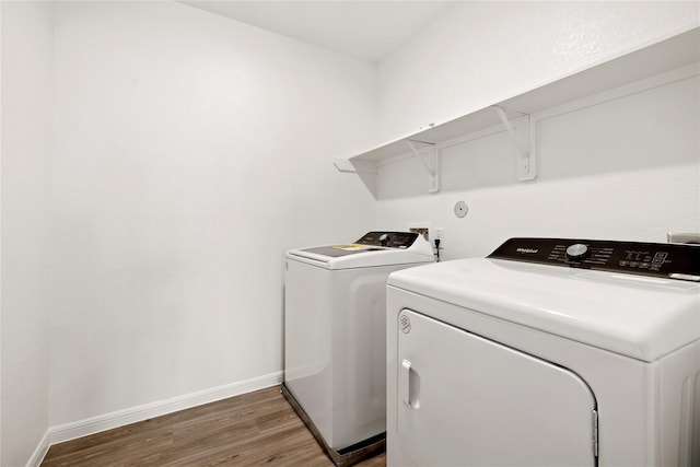 clothes washing area featuring washer and dryer and dark wood-type flooring