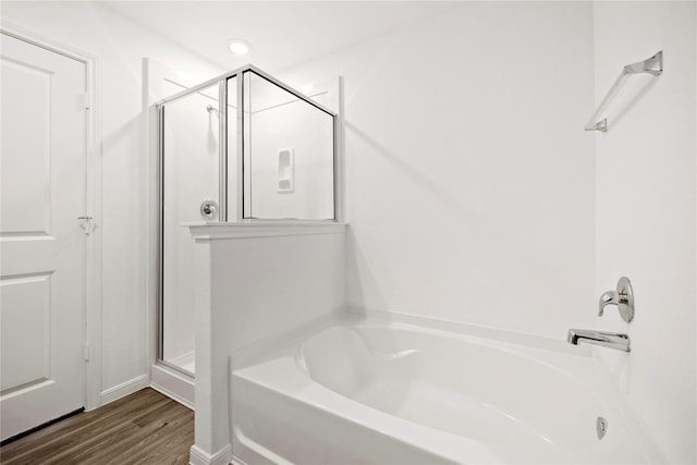 bathroom featuring plus walk in shower and hardwood / wood-style floors