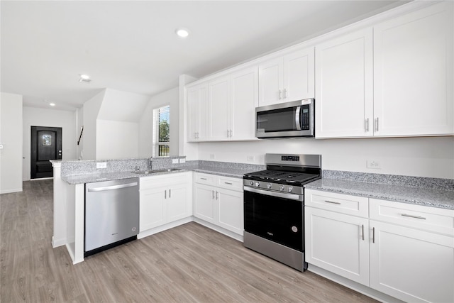 kitchen featuring white cabinets, stainless steel appliances, light hardwood / wood-style flooring, and sink