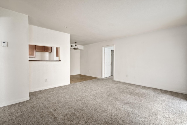 unfurnished room with dark carpet and baseboards