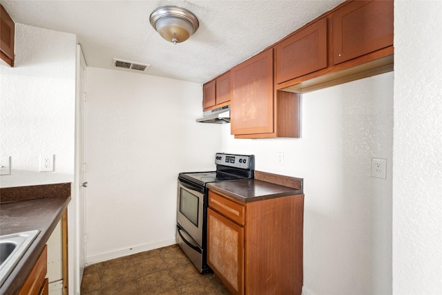 kitchen with visible vents, dark countertops, stainless steel electric range oven, brown cabinets, and under cabinet range hood