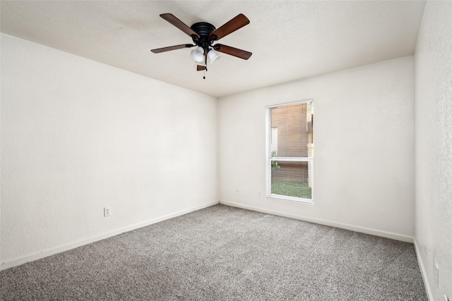 carpeted empty room with ceiling fan and baseboards