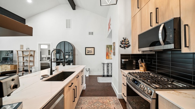 kitchen with sink, light brown cabinets, dark hardwood / wood-style floors, decorative backsplash, and appliances with stainless steel finishes