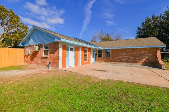 rear view of house with a lawn and a patio area