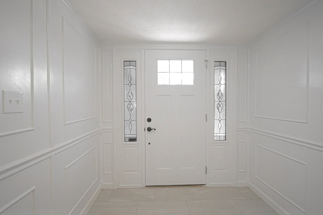 tiled entryway with a textured ceiling