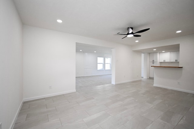 unfurnished living room featuring ceiling fan