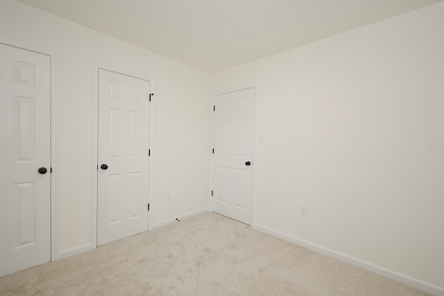 unfurnished bedroom featuring light carpet