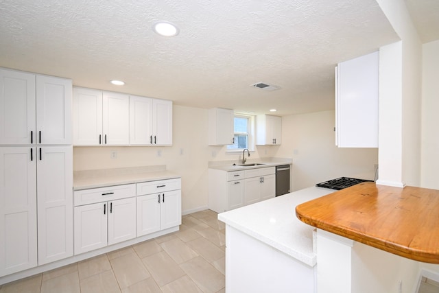 kitchen featuring a textured ceiling, dishwasher, white cabinetry, and sink