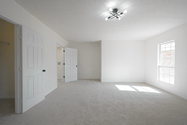 carpeted spare room featuring a textured ceiling