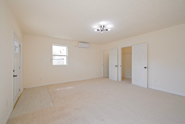 unfurnished bedroom with light colored carpet and a wall unit AC