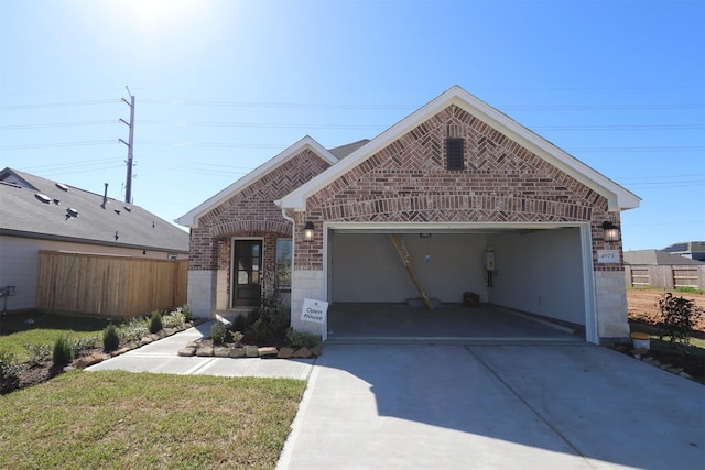 view of front of property with concrete driveway, a garage, fence, and brick siding