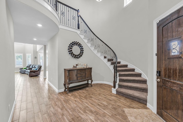 entryway featuring light hardwood / wood-style flooring and a towering ceiling