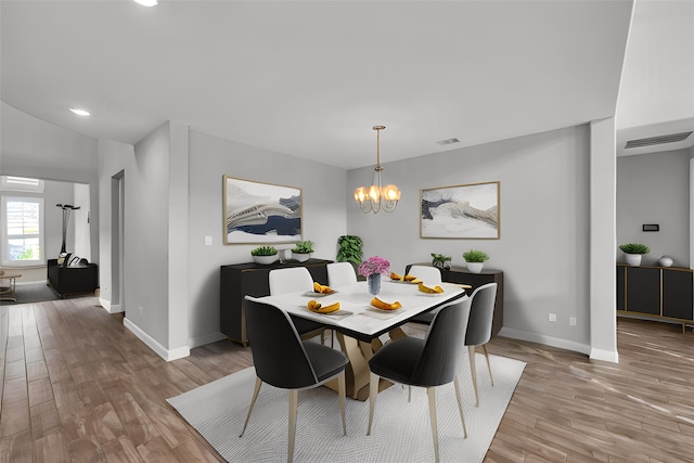 dining space with a notable chandelier and light hardwood / wood-style floors