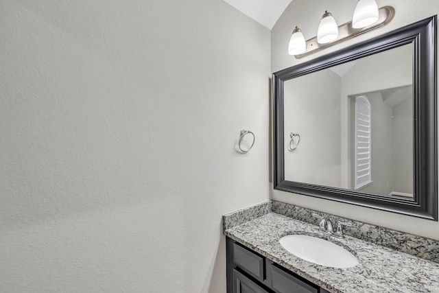 bathroom featuring vanity and vaulted ceiling