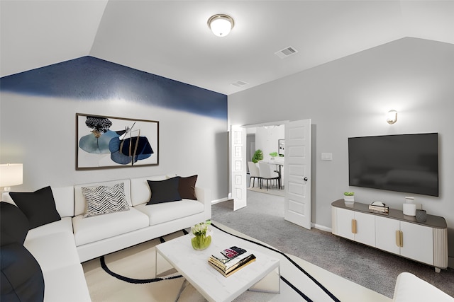 carpeted living room with vaulted ceiling