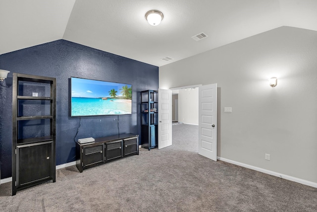 unfurnished living room featuring built in shelves, carpet floors, and vaulted ceiling