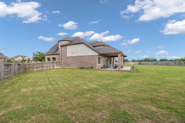 rear view of house with a lawn and a patio