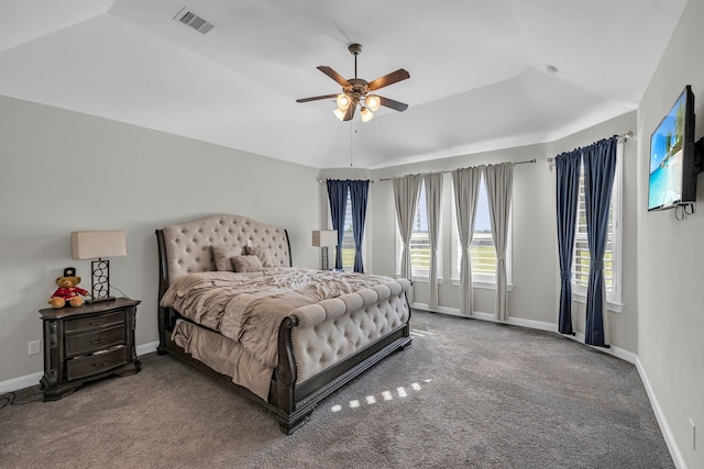 carpeted bedroom featuring ceiling fan and a raised ceiling