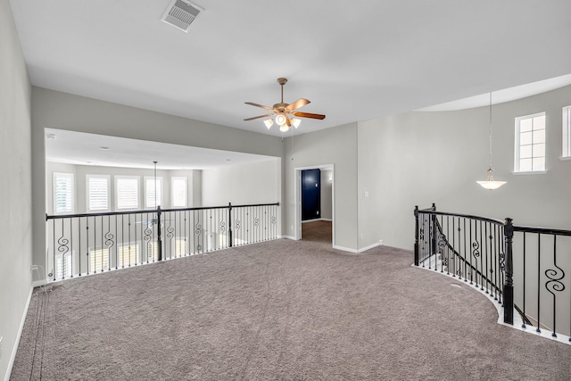 spare room with ceiling fan, plenty of natural light, and carpet floors