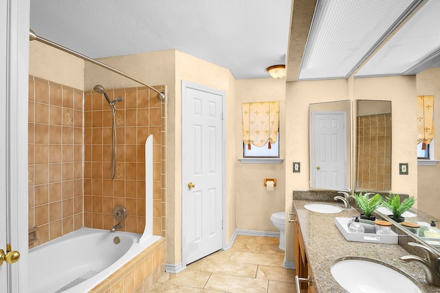 full bathroom with vanity, tiled shower / bath, tile patterned flooring, toilet, and a textured ceiling