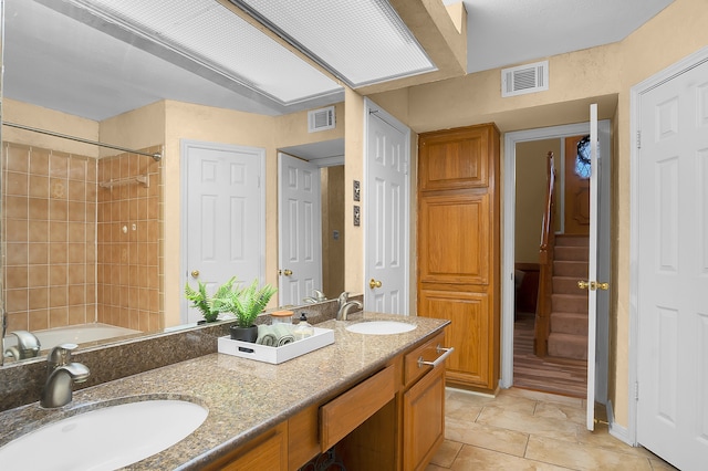 bathroom with tile patterned flooring, vanity, and tiled shower / bath combo