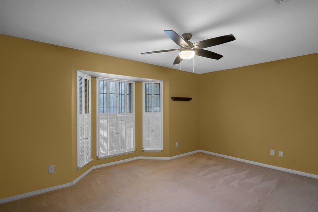 carpeted empty room featuring ceiling fan