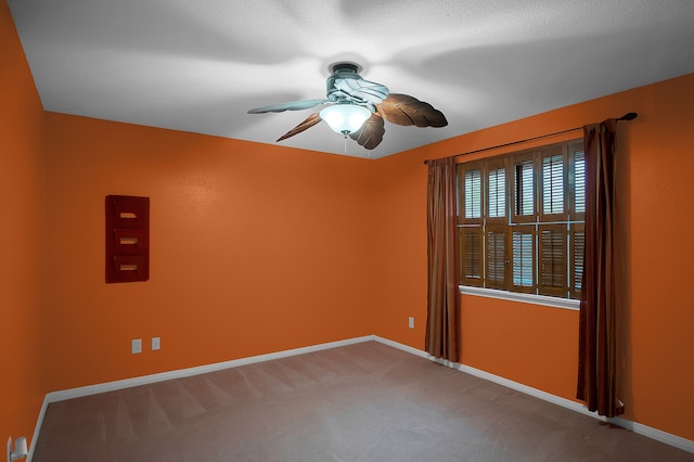 carpeted spare room featuring a textured ceiling and ceiling fan